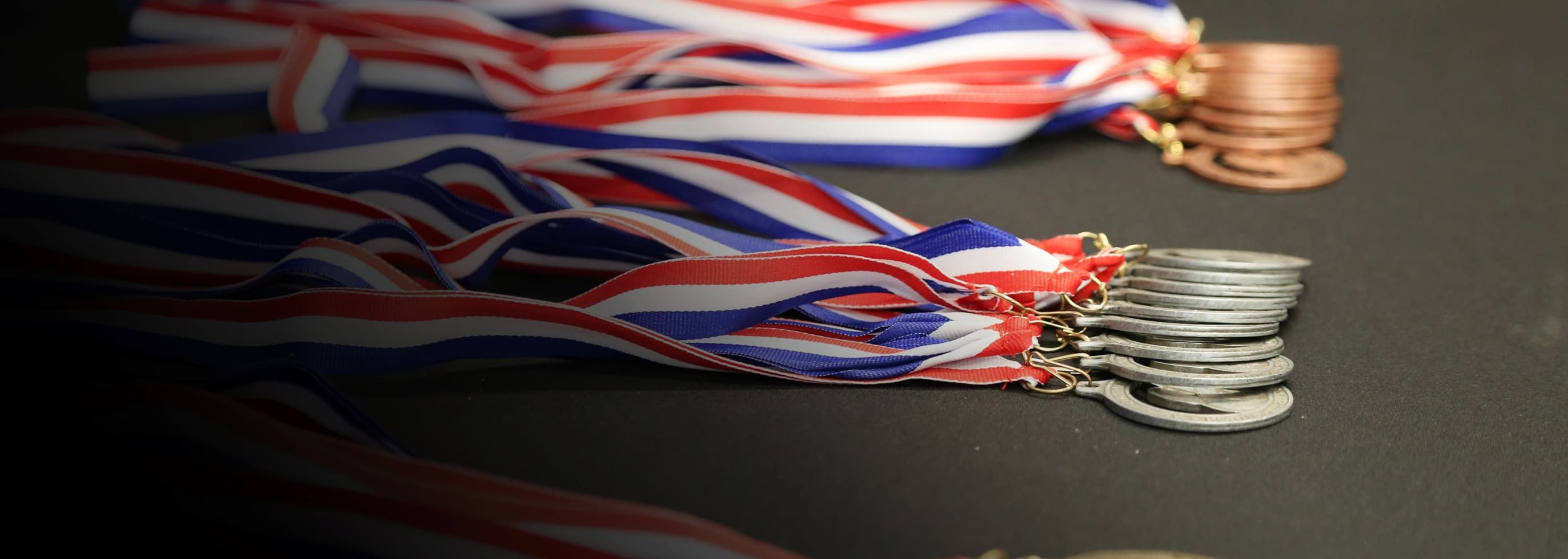 Lots of Skills Canada British Columbia Regional Skills Competition medals laying on the table.