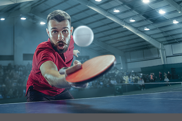 Ping Pong player hitting the ball with paddle